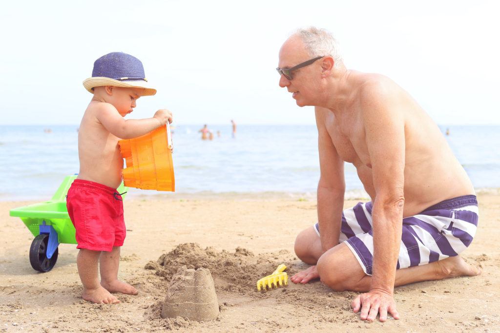 opa met kleinkind speelt op strand