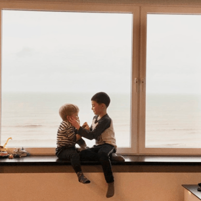 Children by the sea in apartment with sea view